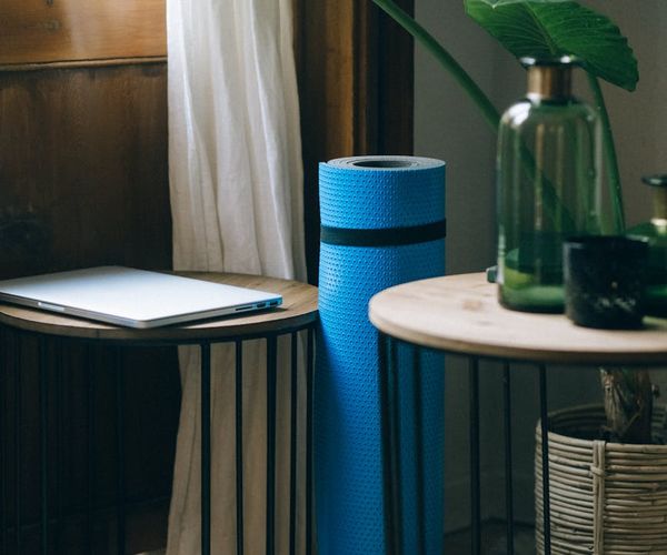 Cozy and calm corner of a room with a yoga mat and a plant.